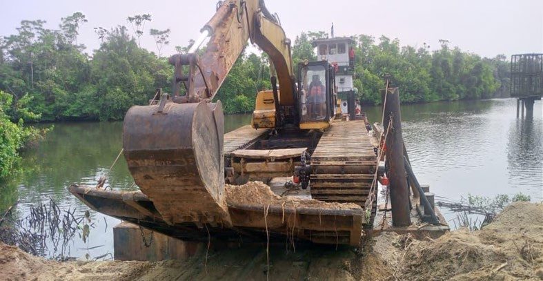 Excavator working from a pontoon in the mangrove waterway on the Aiteo Santa Barbara EPCIC project